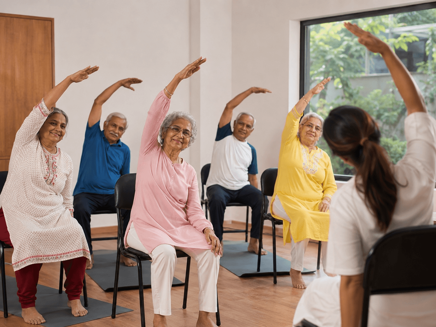 Group of seniors doing chair yoga together in a class